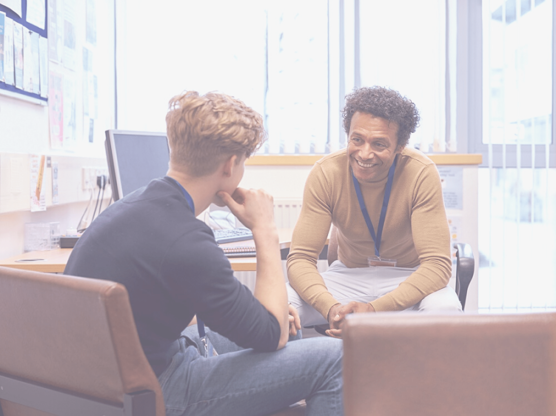 Male College Student Meeting With Campus Counselor Discussing Mental Health Issues