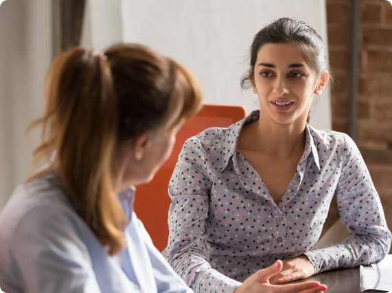 Two employees having a conversation in a workplace