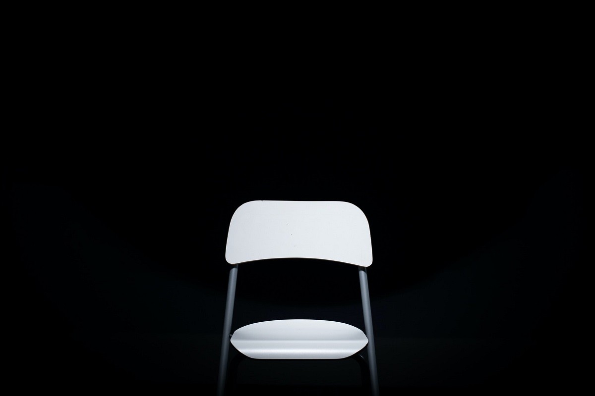 illuminated white plastic chair in a dark room