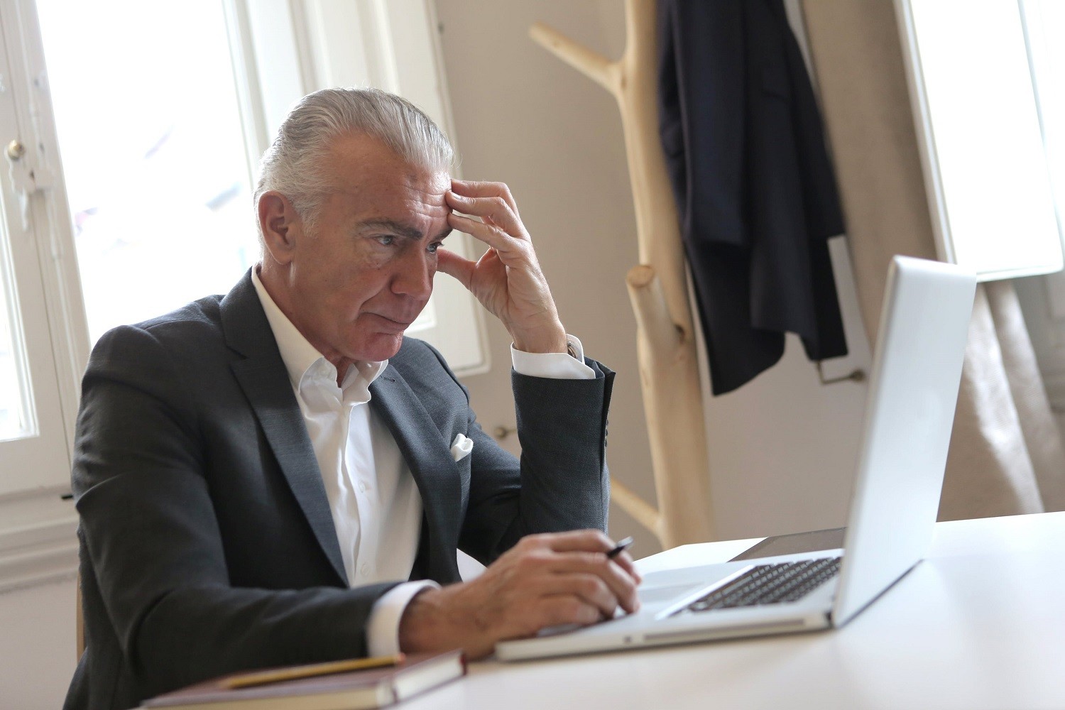 older executive looks as laptop in disbelief