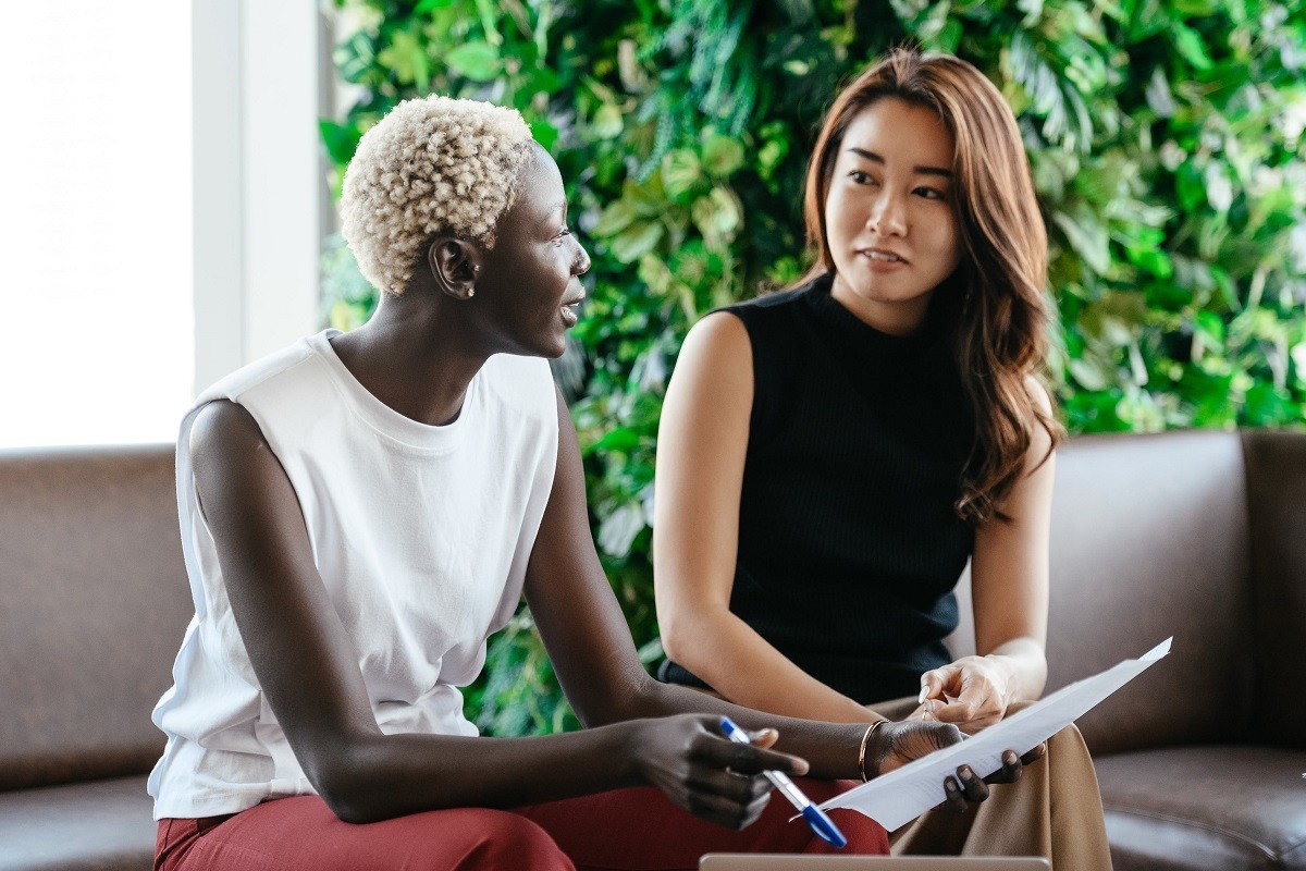 two women sit in a common room in the office and communicate