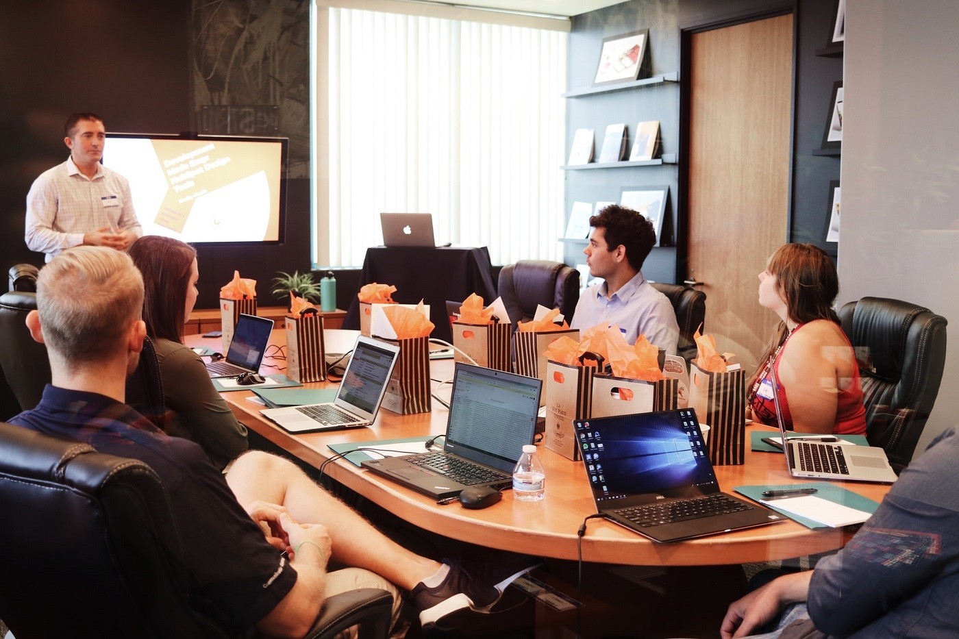 staff attend boardroom meeting with gifts on the table