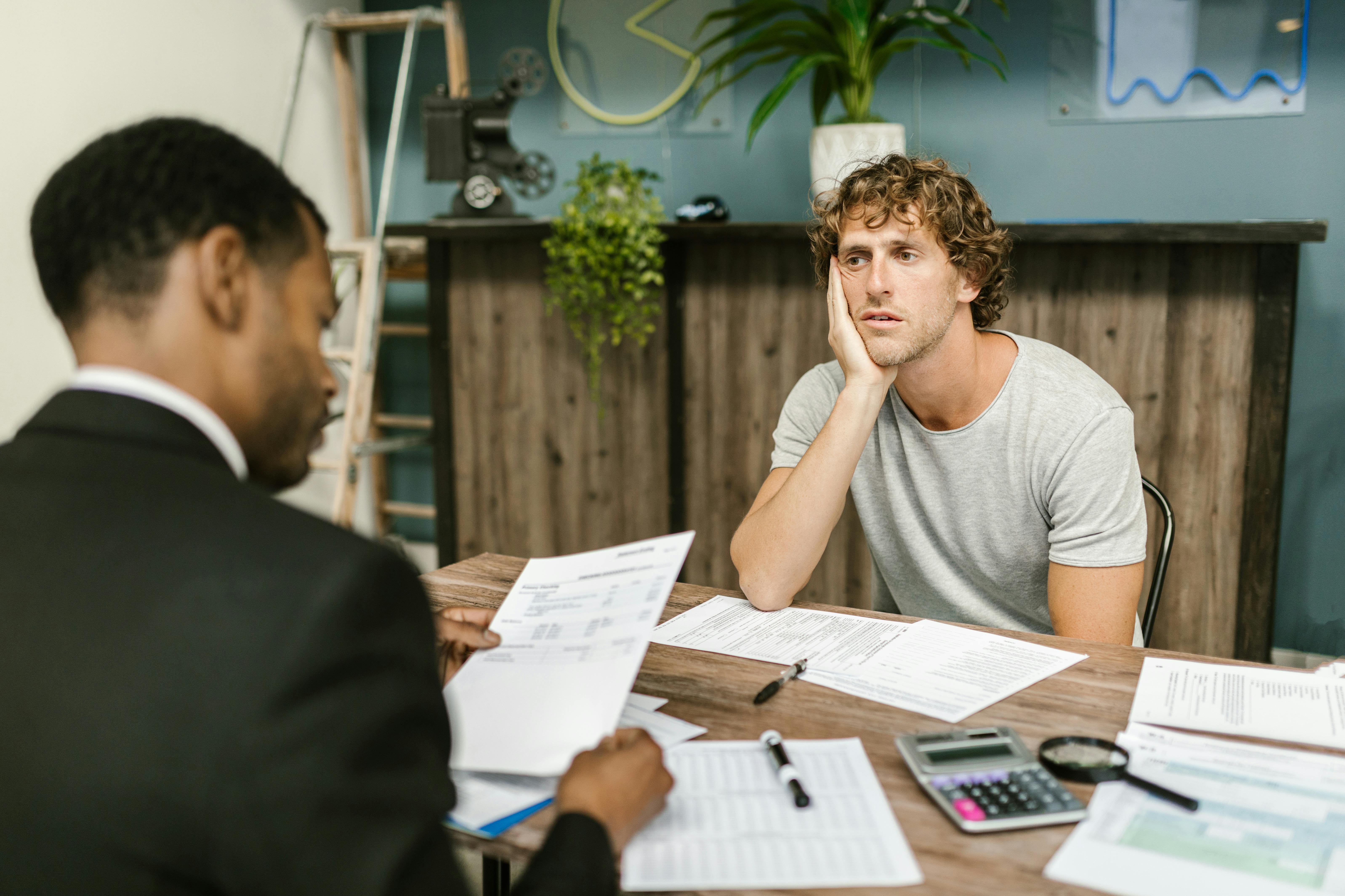 two men sit in an office and look stressed